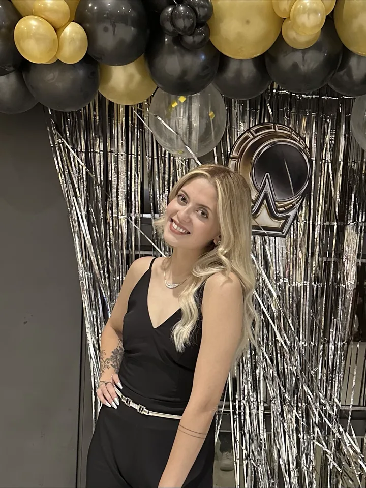 Elina en un evento, con globos y cortina metalizada de fondo